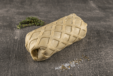 Ein roher, ungebackener Teigwickel mit Rautenmuster, daneben frischer Thymian, grobes Salz und Pfeffer auf dunklem Hintergrund.